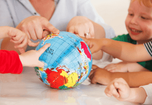 detall d'una familia assenyalant una bola del món